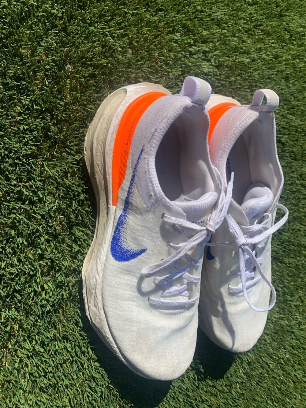 Nike White Running Shoe with Blue Swoosh and Orange Heel Accent